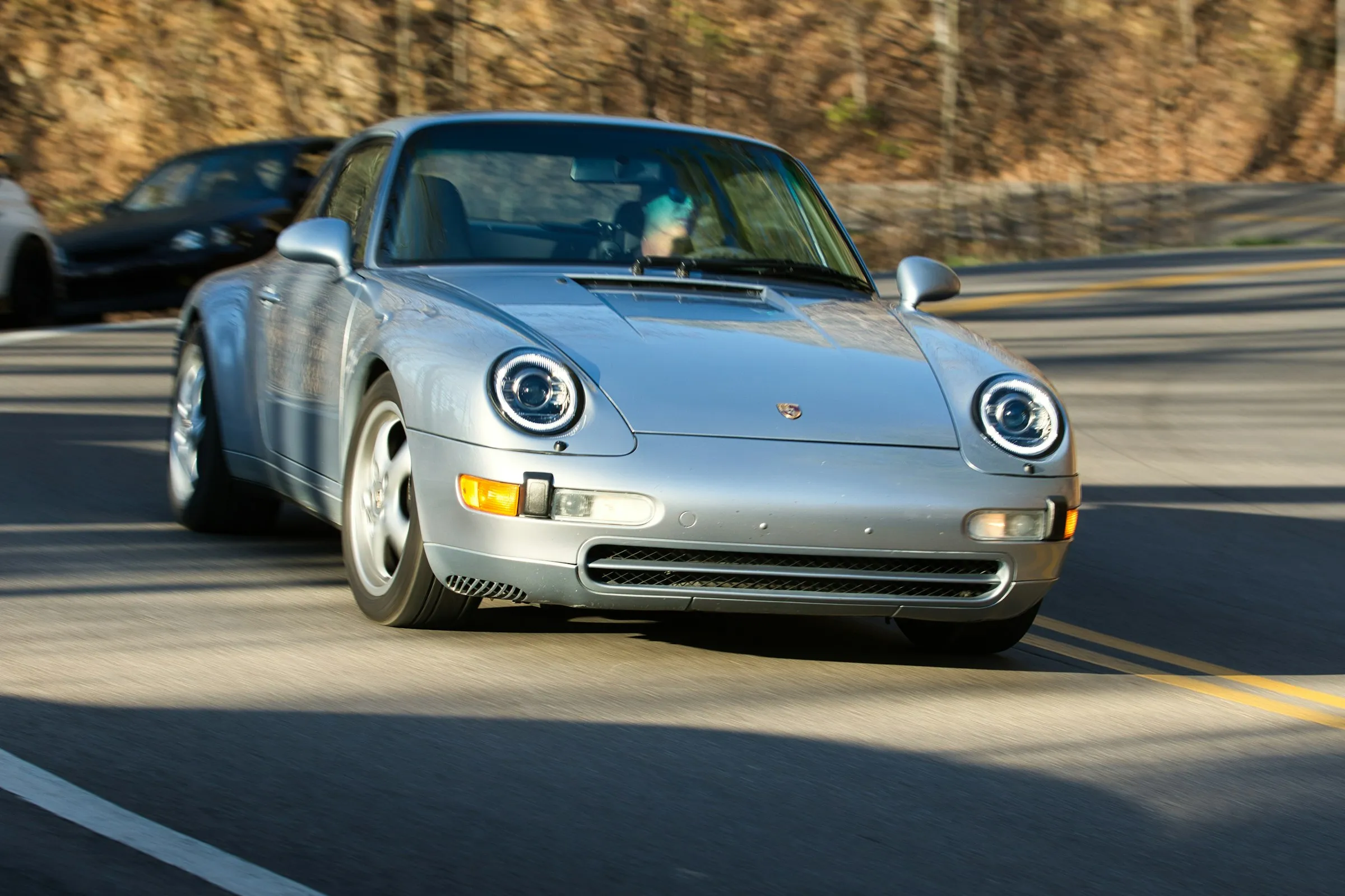 Porsche 911 plateado en una carretera